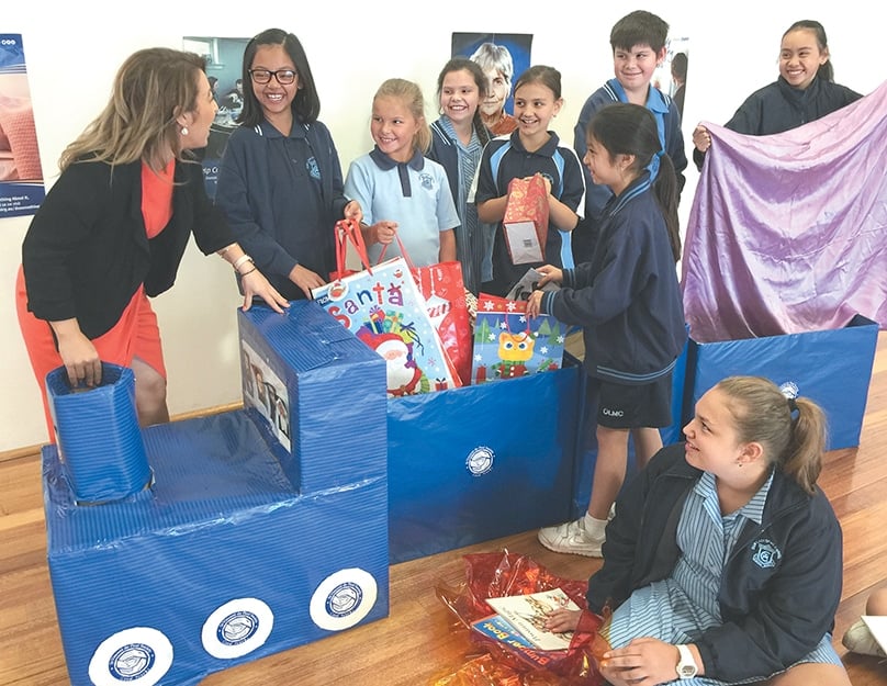 Students from Our Lady of Mount Carmel excitedly pack gifts onto the train. Photo: Supplied