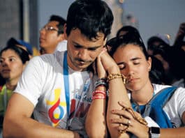 A couple prays after receiving Communion during the opening WYD Mass on 22 January. Photo: Jaclyn Lippelmann, Catholic Standard