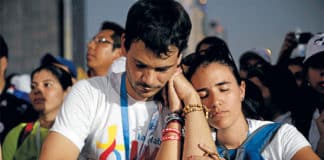 A couple prays after receiving Communion during the opening WYD Mass on 22 January. Photo: Jaclyn Lippelmann, Catholic Standard