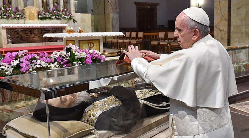 Pope Francis places a stole on a glass case containing the body of St. Pio in the Church of Santa Maria delle Grazie at the Shrine of St. Pio of Pietrelcina in San Giovanni Rotondo, Italy in March 2018. Photo: CNS photo/courtesy Shrine of St. Pio of Pietrelcin