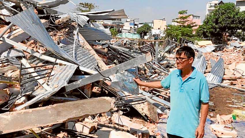 A local surveys the damage in the Catholic parish of Loc Hung