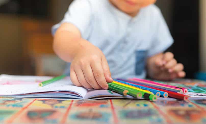 child with colour pencils