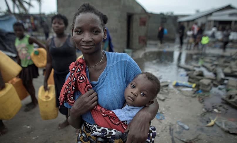 A woman carries a child March 17, 2019, in the aftermath of Cyclone Idai in Beira, Mozambique. Photo: CNS photo/Josh Estey, Care International via Reuters