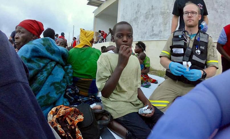 A boy eats as rescue workers help residents affected by Cyclone Idai in Beira, Mozambique, March 19, 2019, in this still image taken from a social media video. Photo: CNS photo/IPSS Medical Rescue via Reuters