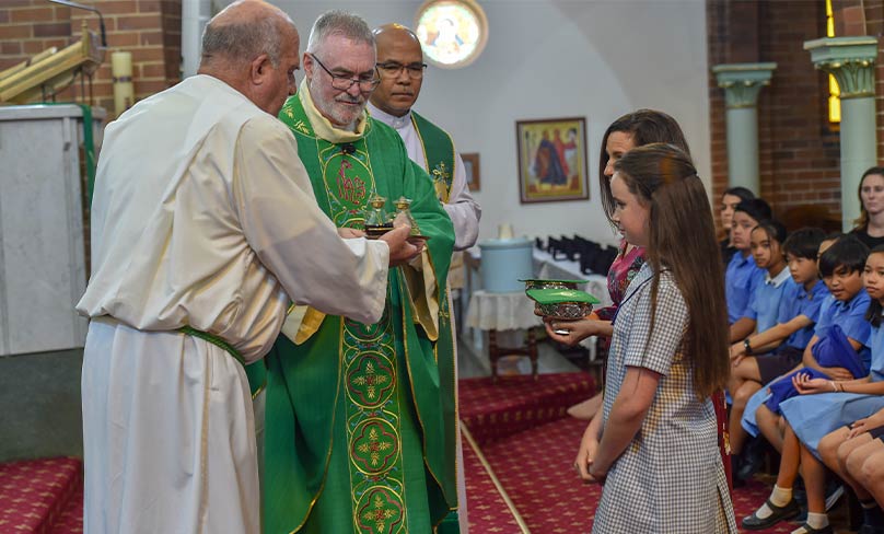 Pope Francis award recipient Amelia Roche takes up the Offering during Mass. Photo: Kitty Beale