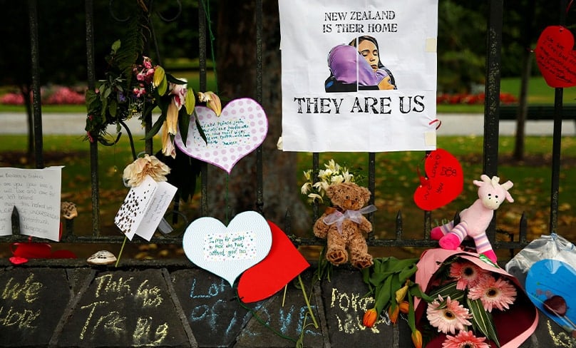 Flowers and signs are seen at the Botanic Gardens in Christchurch, New Zealand, in a makeshift memorial. Photo: CNS photo/Edgar Su, Reuters