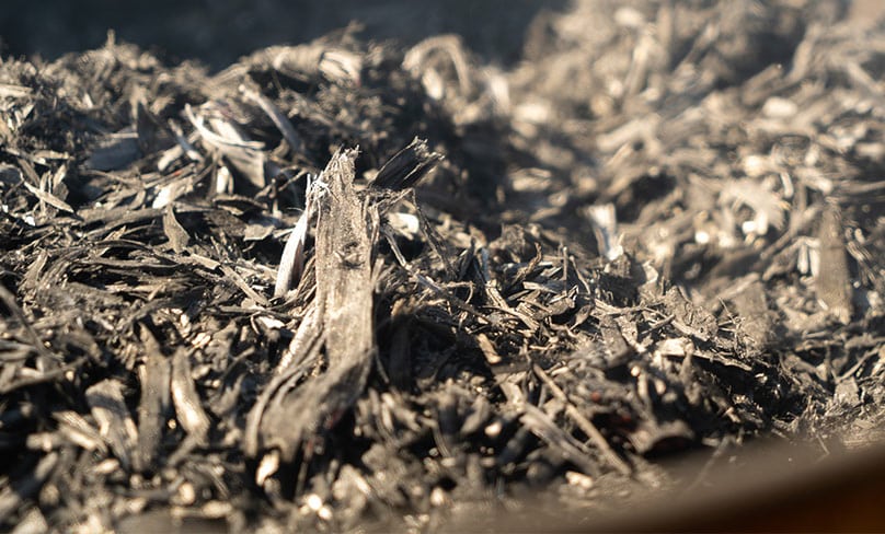 A pile of ash smolders from six baskets of burned palm branches. Photo: CNS/Katie Rutter