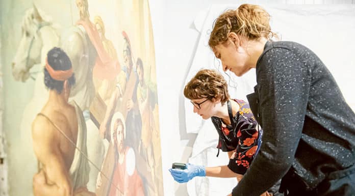 Specialist restorers examine one of the Stations of the Cross. Photo: Giovanni Portelli