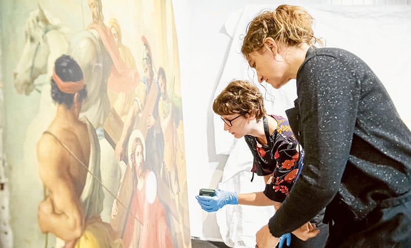 Specialist restorers examine one of the Stations of the Cross. Photo: Giovanni Portelli