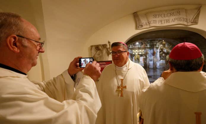 Father Stephen Hackett, secretary general of the Australian Catholic Bishops Conference, takes a photo of Bishop Michael McCarthy of Rockhampton, Australia, at the tomb of St. Peter, Photo: CNS photo/Paul Haring