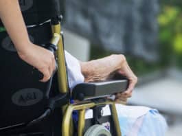 woman with elderly man in wheelchair.