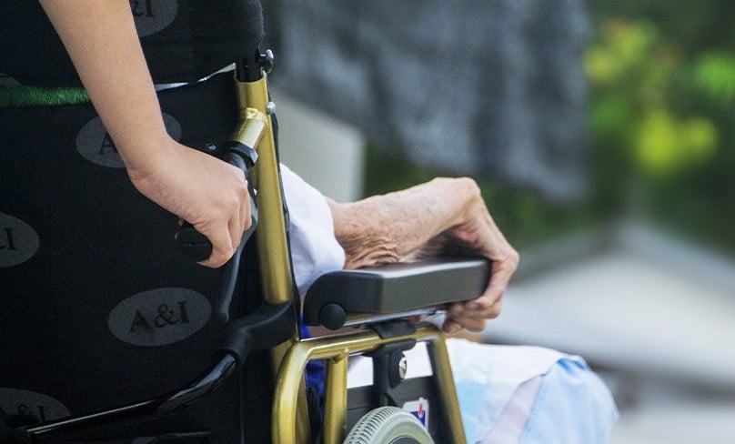 woman with elderly man in wheelchair.