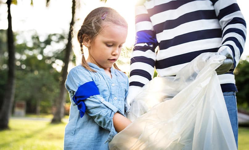 Girl picking up rubbish.