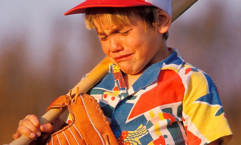 Child cries holding baseball bat
