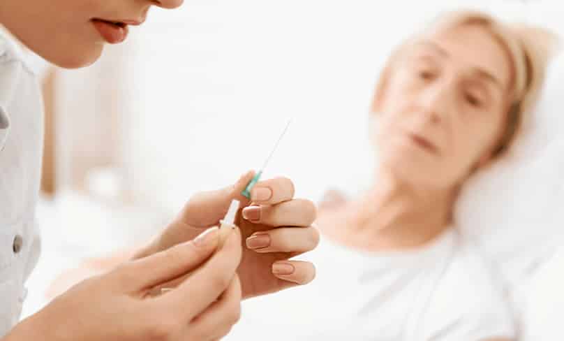 Nurse prepares needle for hospital patient