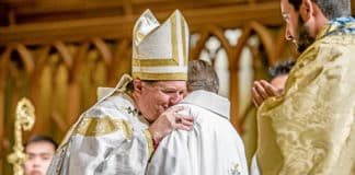 Archbishop Anthony Fisher OP embraces newly-ordained Fr Tom Stephens, welcoming him to the priesthood on 15 August 2015. Photo: Giovanni Portelli