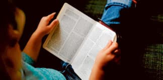 Child reads the Holy Bible.