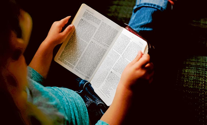 Child reads the Holy Bible.