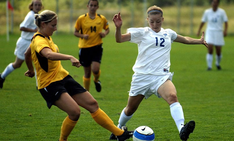 Girls playing on a soccer field.