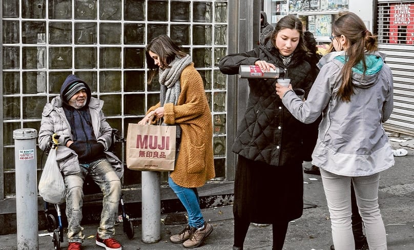 Teresa Hodal (second right) and fellow ESM participants offer hot food to the homeless in New York.