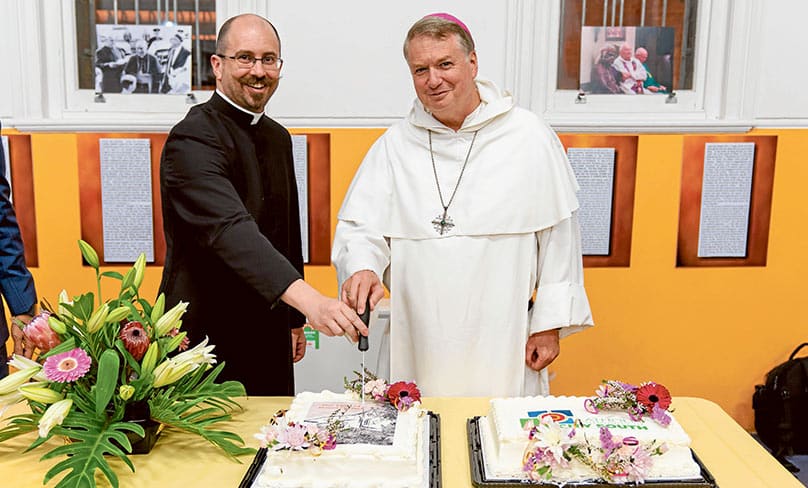 Fr Smithers and Archbishop Fisher cut the cake at a celebration at Waterloo in 2019. Photo:: Alphonsus Fok