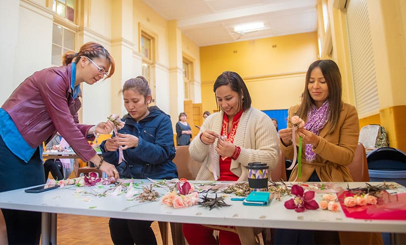 TAFE teacher Tina Nguyen helps some the participants during the floristry workshop. Photo: Giovanni Portelli