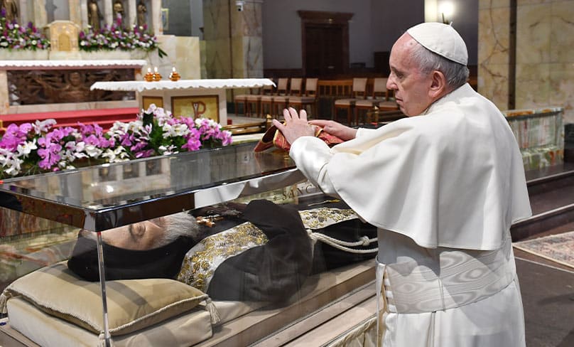 Pope Francis places a stole on a glass case containing the body of St. Pio in the Church of Santa Maria delle Grazie at the Shrine of St. Pio of Pietrelcina in San Giovanni Rotondo in Italy. Photo: CNS photo/courtesy Shrine of St. Pio of Pietrelcina