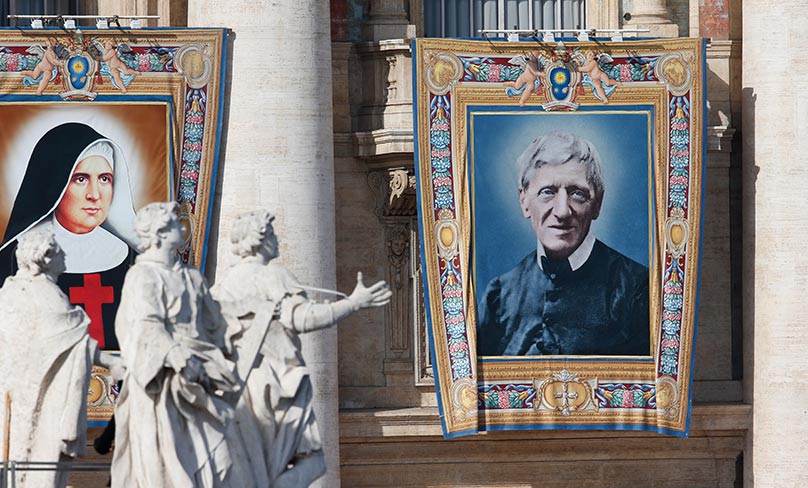 Banners showing new Sts. Giuseppina Vannini and John Henry Newman hang from the facade of St. Peter's Basilica as Pope Francis celebrates the canonisation Mass for five new saints in St. Peter's Square at the Vatican. Photo: CNS photo/Paul Haring