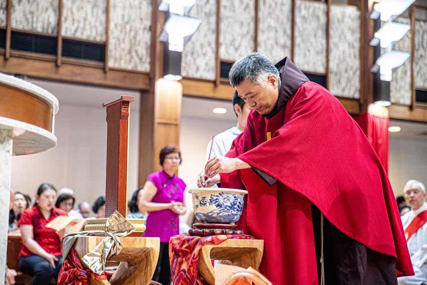 Fr Joseph Lu OFM prepares an offering of incense and prayers for deceased relatives. PHOTO: Alphonsus Fok