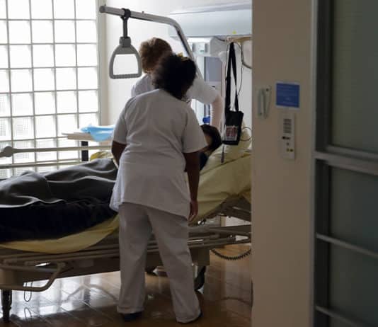 Nurses provide care to a patient in the palliative care unit of a hospital near Paris. Photo: CNS photo/Philippe Wojazer, Reuters