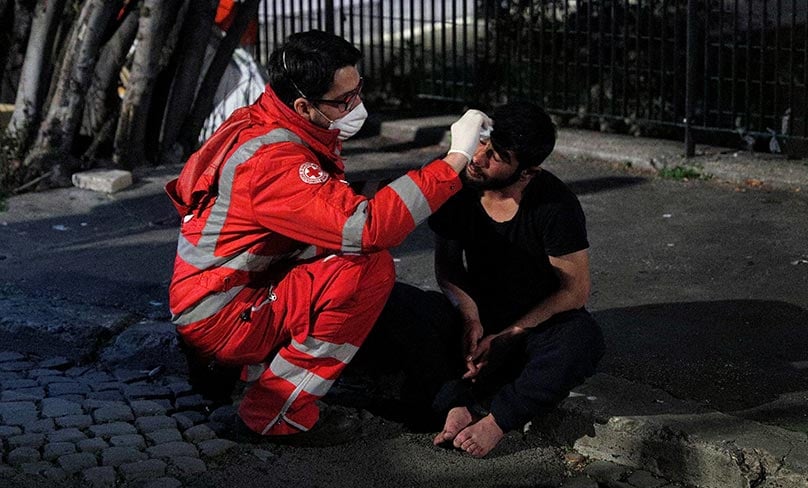 A homeless person is treated by a Red Cross worker during the COVID-19 outbreak in Rome. Photo: CNS/Guglielmo Mangiapane, Reuters