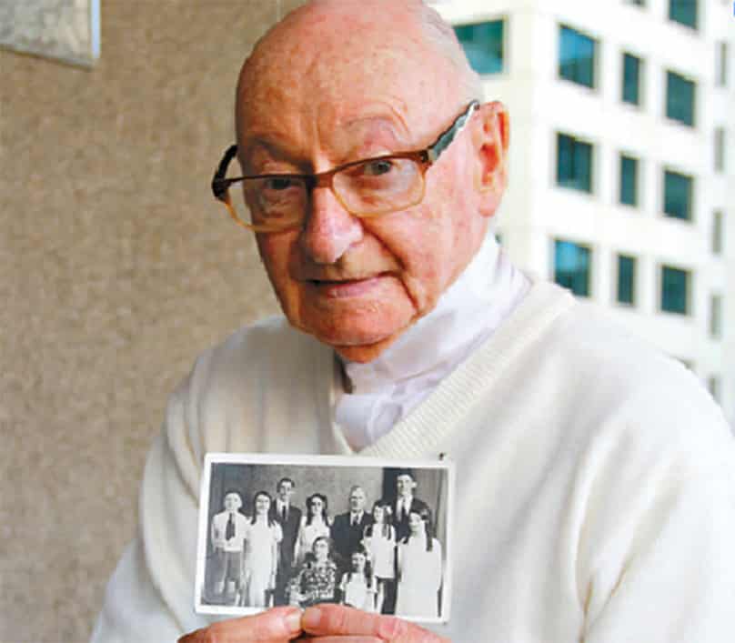 Father William Creede CSsR holds a family photo. 