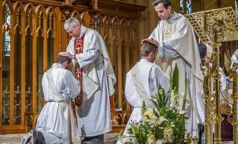 Bishop Richard Umbers and a fellow priest pray over the newly ordained. Photo: Giovanni Portelli