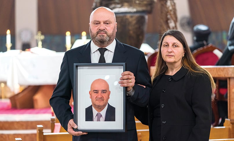 Raymond and Louise Merhi hold a photo of Raymond’s brother Joseph, aged 50, who died in the blast on 4 August in Beirut. Photo: Patrick J Lee