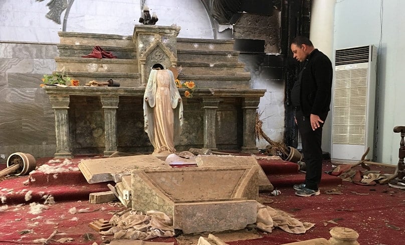 A Catholic church destroyed by Islamic State militants in Karamdes, Iraq, is examined by a priest following the 2016 liberation of the predominantly Christian town. Photo: CNS photo/courtesy Archdiocese of Irbil