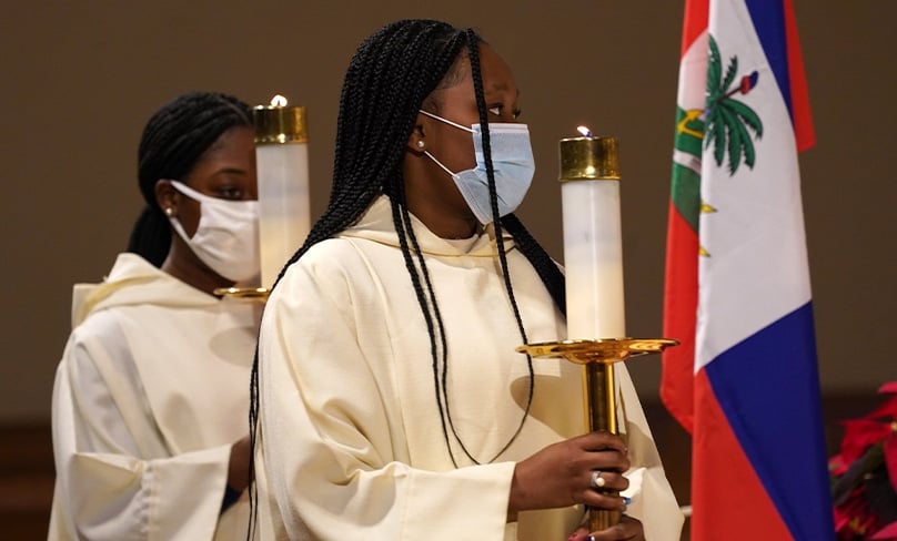 Altar servers process past a Haitian flag during a Mass for Catholics of Haitian ancestry on the feast of Mary, Mother of God, at St. Agnes Cathedral in Rockville Centre, N.Y., Jan. 1, 2021. Photo: CNS photo/Gregory A. Shemitz