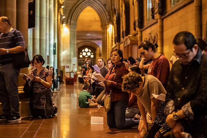 Worshippers kneel in prayer in St Mary's Cathedral during the Commemoration of the Lord's Passion. Photo: Giovanni Portelli