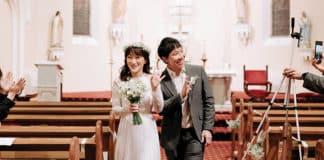 Jason and Sujin Wong wave to the cameras as they leave St Peter Chanel Catholic Church at Hunters Hill as newlyweds. PHOTO: Snapsby_Tiffany