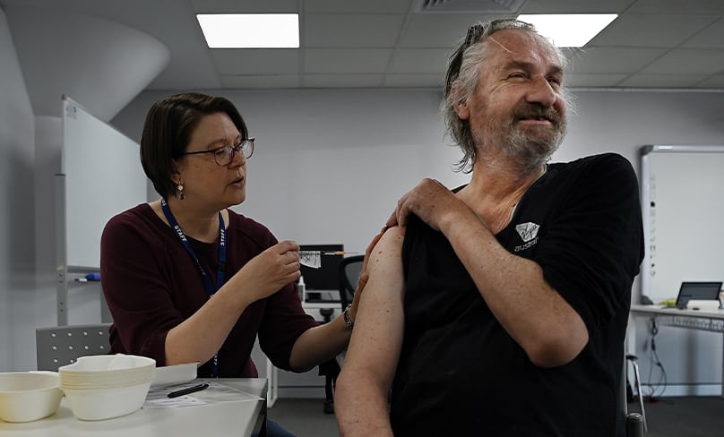 Rolling up sleeves to help … a St Vincent’s Hospital worker vaccinates a rough sleeper at the Matthew Talbot Hostel in Woolloomooloo. Photo: Kate Geraghty