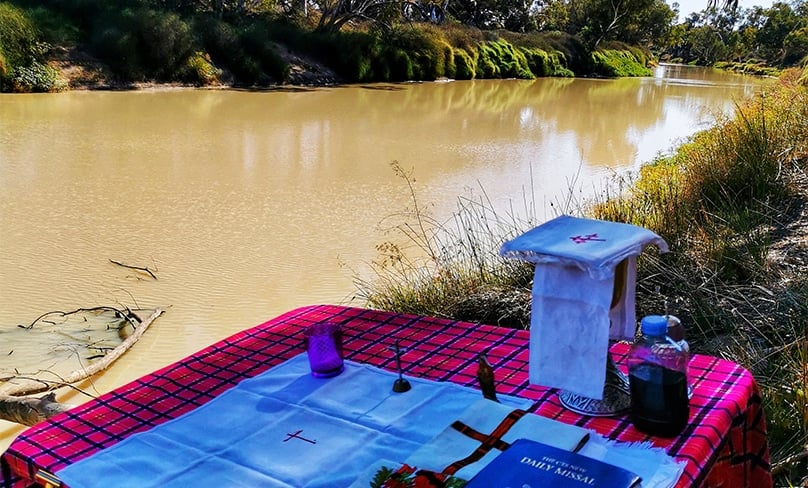 Fr Harold prepares for a Mass beside Cooper Creek at Innamincka. Photo: Supplied