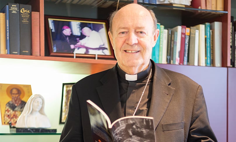 Archbishop Julian Porteous of Hobart holds a copy of his new book on the Plenary Council in his office. Photo: Mark Franlin