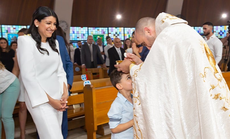 Fr Charbel blesses one of his childen while his wife and another son look on. Photo: Supplied