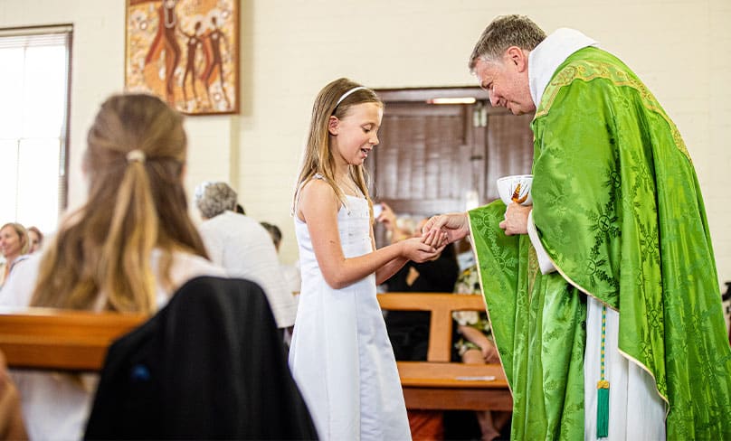 Archbishop Anthony Fisher OP distributes the host to those making their First communion at the Aboriginal Catholic Ministry in 2019. Photo: Alphonsus Fok