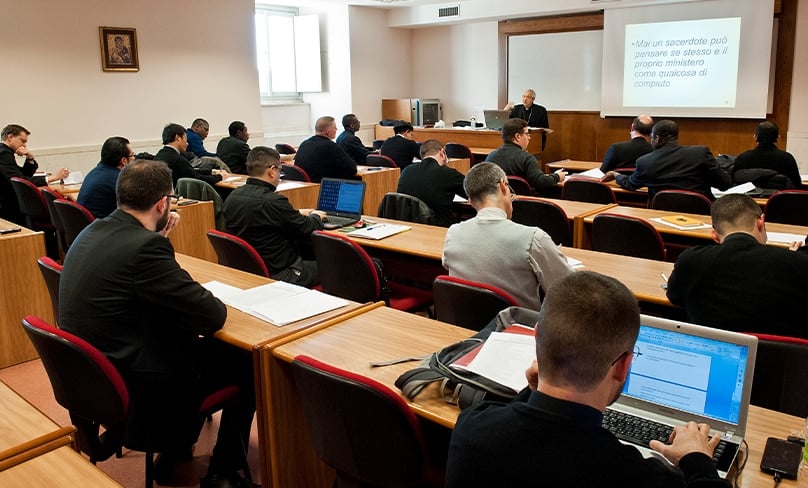 Students take notes during a class at the Pontifical University of the Holy Cross. Photo: PUHC
