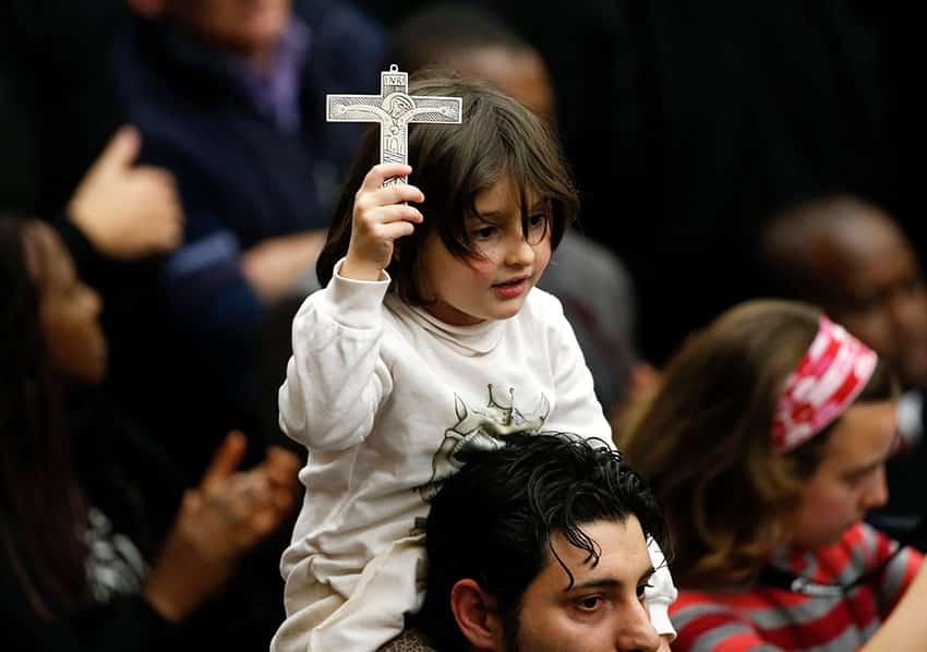 Modeling our love for our faith and gently removing obstacles to their encounter with our Lord is the best way to succeed at Mass with kids. Photo: CNS, Tony Gentile, Reuters