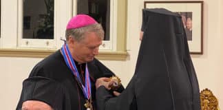 Archbishop Fisher receives award from Archbishop Makarios Griniezakis.