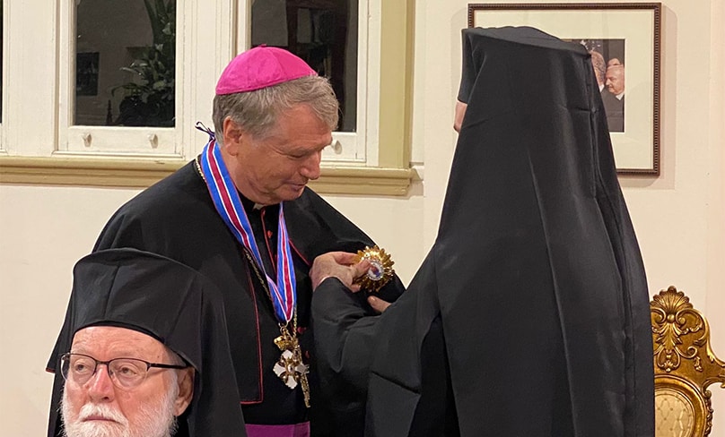 Archbishop Fisher receives award from Archbishop Makarios Griniezakis.