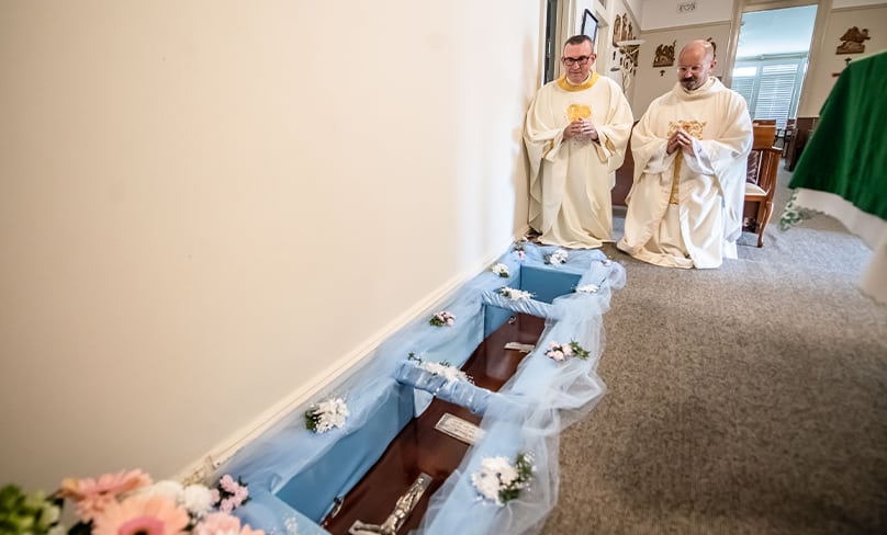 Frs John Knight and Paul Smithers pray before the coffin holding the remains of Servant of God Eileen O’Connor. Photo: Giovanni Portelli