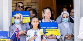 Ukrainian Catholics hold signs urging solidarity with beleaguered Ukraine at the rally following the prayer service. Photo: Alphonsus Fok