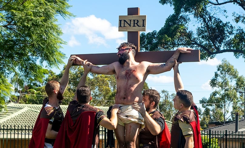 Roman soldiers drag a beaten down Jesus through the grounds of the adjacent school to the oval where the final stations of Our Lord’s Passion were emotionally depicted. Photo: Mat De Sousa